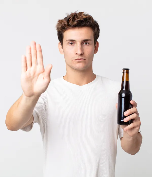 lost angels alcohol detox man holding beer bottle making stop