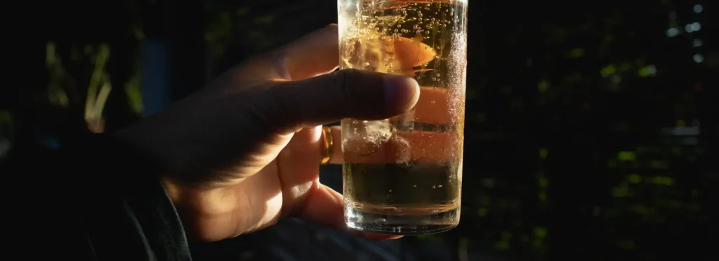 Person holding a glass with a cocktail.