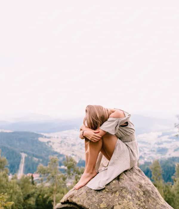 lost angels mental health woman sitting top rock looking out